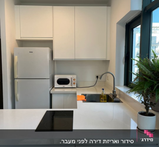מטבח מאורגן עם מקרר, מיקרוגל וכיור